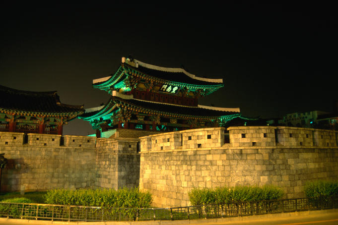 Old city walls and gate at night.
