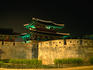 Old city walls and gate at night.