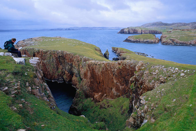 Walking the red granite coastline od Muckle Roe on the Shetland Islands.