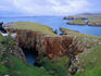 Walking the red granite coastline od Muckle Roe on the Shetland Islands.