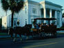 A horse-drawn carriage takes tourists past an old mansion on South Battery Street.