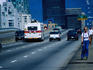 A roller blader and traffic on Granville Bridge with Vancouver skyline in the background.