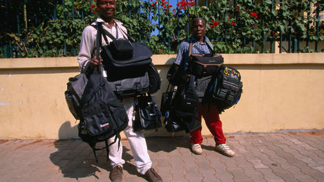 Maputo street vendors selling bags and backpacks.