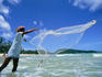 Fisherman casts his drift net off Patong Beach.