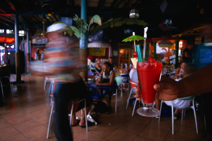 Hand holding strawberry daquiri in Margueritaville Bar.