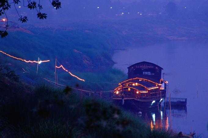 The floating restaurant " La Monarque " moored on the banks of the Mekong River, Laos' major highway