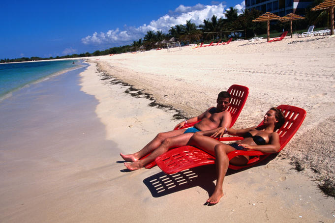 Couple sunbathing on shore of Playa Ancon.