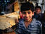 A young boy buying bread in the Shiraz bazaar.