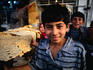 A young boy buying bread in the Shiraz bazaar.