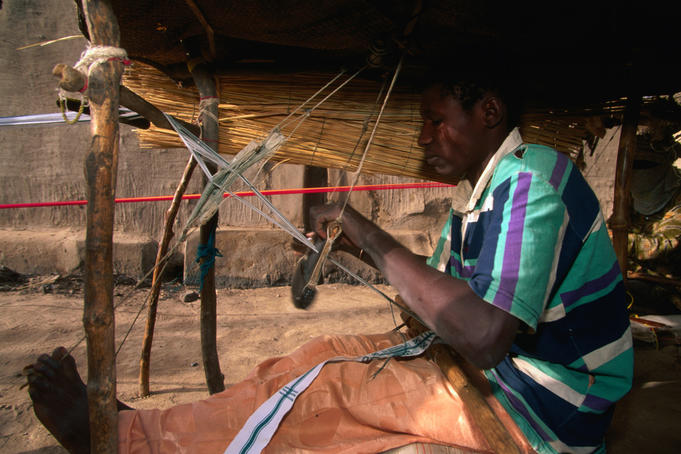 A seated weaver in his open air workshop at Mopti.