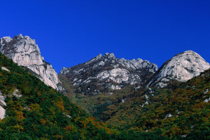 The massive white granite peaks and verdant forests of Puk'Ansan Park just north of Seoul. The peaks are popular with climbers.