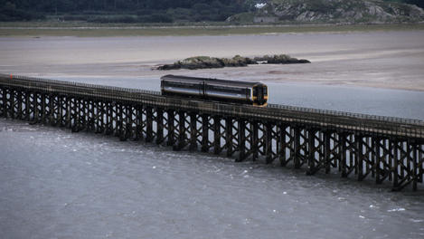 Train crossing the wooden Barmouth railway viaduct, the longest in the UK.