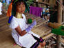 A young girl from the Longneck (Shan) village wearing the traditional Longneck jewellery sitting on the porch of a house