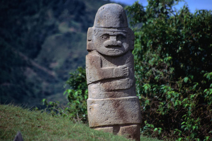 Ancient stone statue, depicting a figure with folded arms, at the San Agustin Archaeological Park.