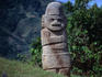 Ancient stone statue, depicting a figure with folded arms, at the San Agustin Archaeological Park.