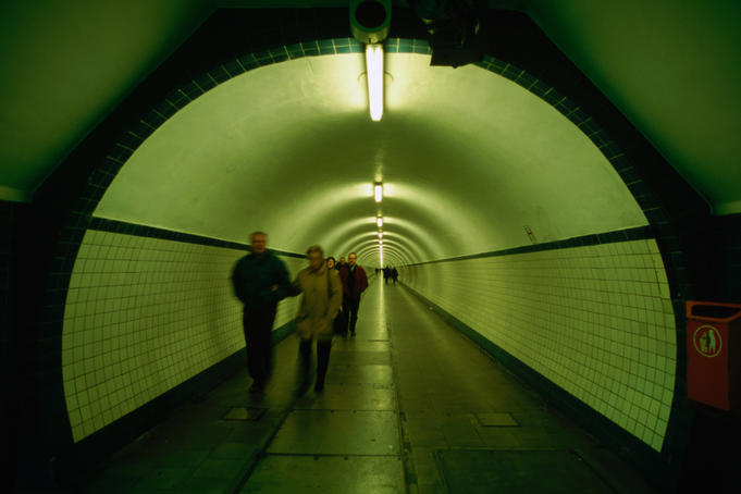 People walking through St Anna Tunnel, a pedestrian tunnel under the Schelde river (built 1931-1933).