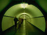 People walking through St Anna Tunnel, a pedestrian tunnel under the Schelde river (built 1931-1933).