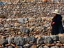 Local walking past rows of stone walls.