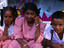 Three kids on their way to school in Chennai do their best not to smile for the camera