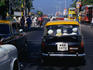 Passengers in a taxi stop at an intersection in Mumbai.