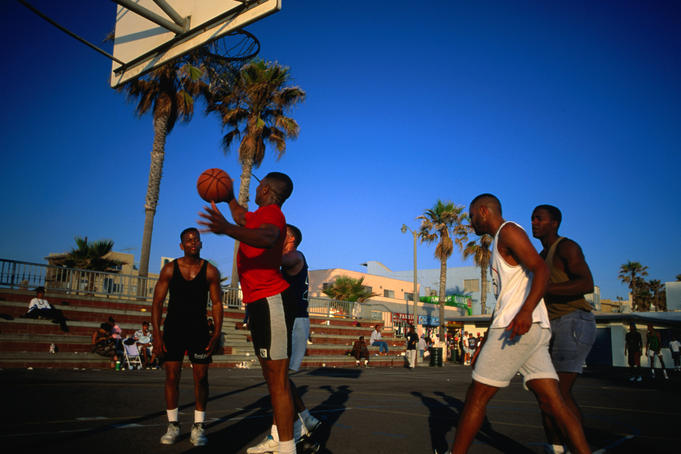 Early afternoon and a game of basketball in action on Venice Beach in Los Angeles.