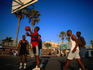 Early afternoon and a game of basketball in action on Venice Beach in Los Angeles.