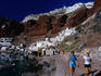 The town of Oia sits on red cliffs overlooking the waterfront village of Ammoudi, Santorini island.