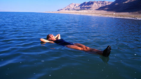 Woman floating in Dead Sea waters.