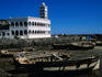 Boats in a dried up harbour and a mosque in the background.