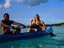 Tourist canoeing with a local man in the ocean.