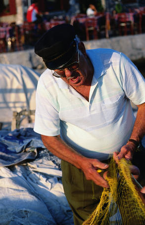 Fisherman repairing his net.