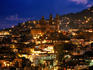 Iglesia Santa Prisca and hillside houses lit up at dusk, Taxco