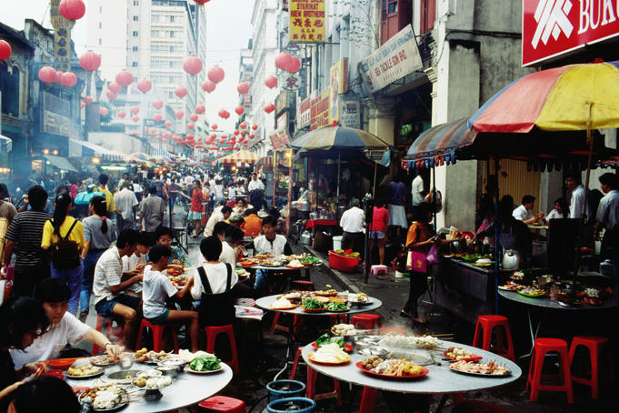 Eating at outdoor restaurants in busy street.