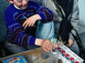 Young vendor in the Grand Bazaar under the watchful supervision of his grandmother, Istanbul.
