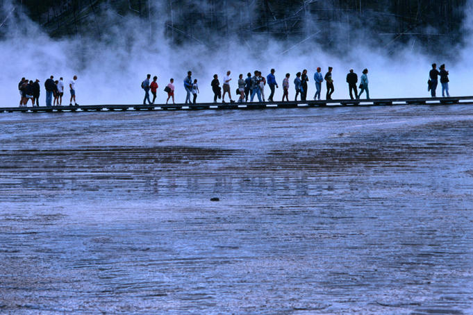 Hikers walking along a boardwalk at Midway Geyser Basin.