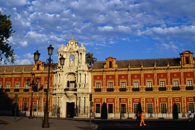 The Palace of San Telmo (1682) is one of the best examples of the Seville baroque style. The cream front portal houses a statue of St. Telmo holding a ship and charts. Formerly a marine university it now houses the Andalucian regional government.
