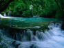 Water cascading from a wide flat pool: one of the many waterfalls in the Plitvice Lakes National Park.
