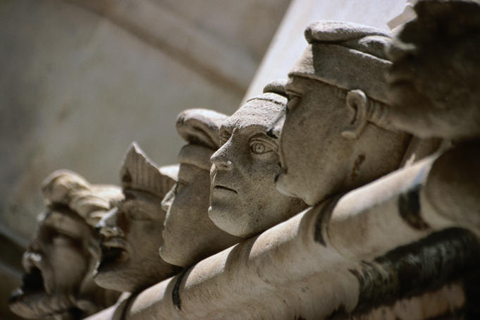 A row of carved stone heads on top of the walls outside the apse of the Cathedral of St Jacob.