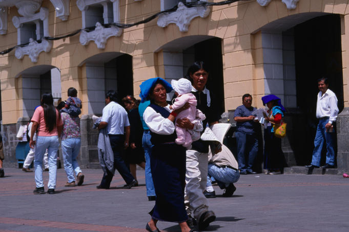 Indian family on Plaza de la Independencia. The mother is wearing traditional dress- Quito, Ecuador