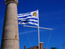 Uruguayan flag flying before faro (lighthouse).