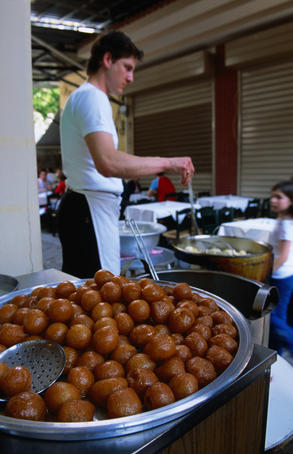 Loukamades soaked in syrup, ready to eat.