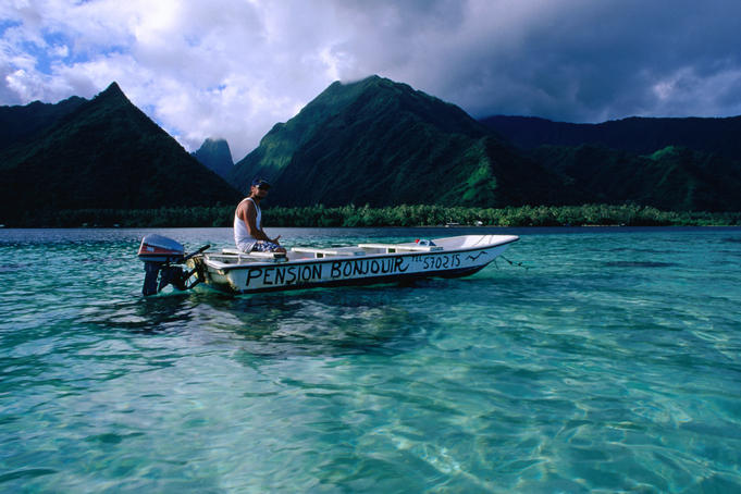 Local pension owner cruising his dinghy along the peninsula called Tahiti Iti near the Te Pari cliffs.