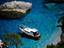 Boat anchored in shallow waters off beach.
