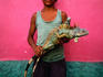 Young boy holding an endangered iguana. His poverty may lead him to sell it as food - Kilometro Treinta.