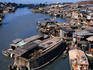 Houseboats and houses on banks of Saigon River.