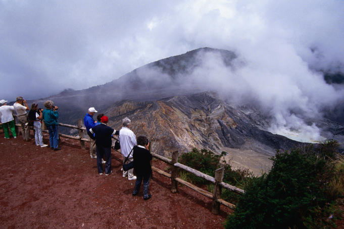 Visitors regard Poas Volcano, a stratovolcano with both an active and a dormant volcano. The crater has been active since 1834.