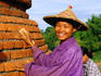 A smiling girl repairing a small stupa next to Yadanapon Paya temple.