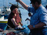 A fisherman weighs octopus in Mykonos Harbour.