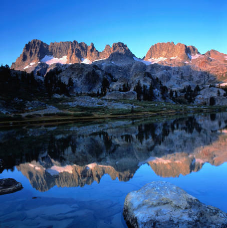 Sierra Nevada mountains reflected in still lake waters.