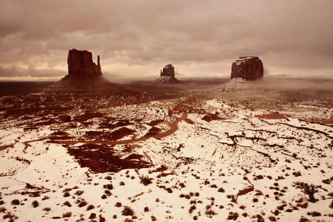 Snow covered valley and rock formations.